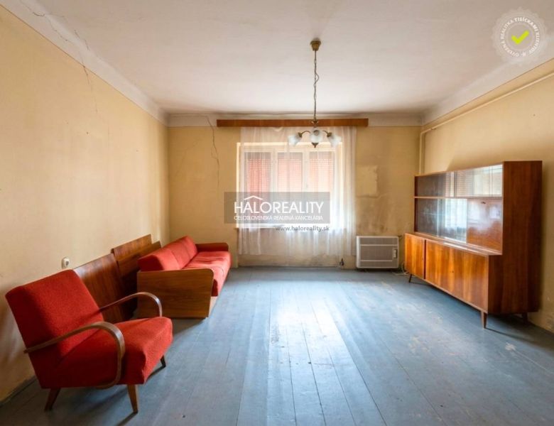 Living room in a family house with older furniture and wooden floor decor.