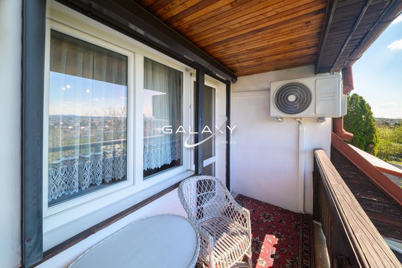 A balcony of a family house in Rimavská Sobota with rattan furniture and air conditioning.