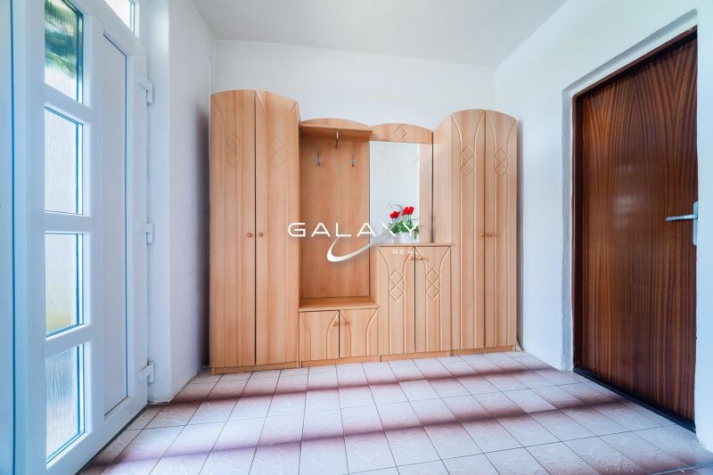 Hallway with a built-in wooden wardrobe and a plant, Family house.