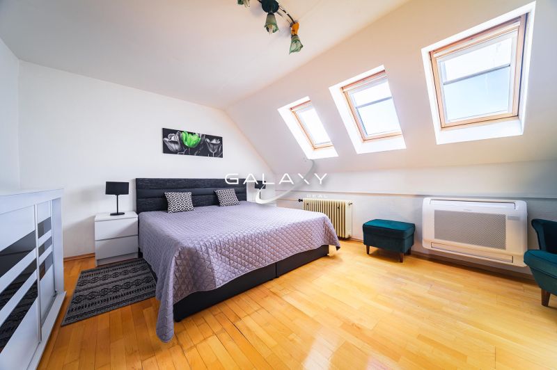 A bedroom in a family house with a wooden decor floor and skylights.