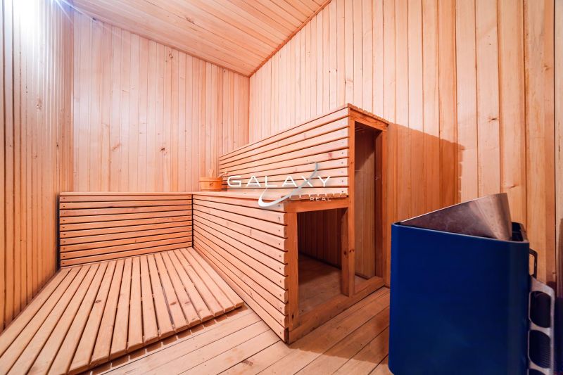 A wooden sauna in a family house with benches and a stove for heating.