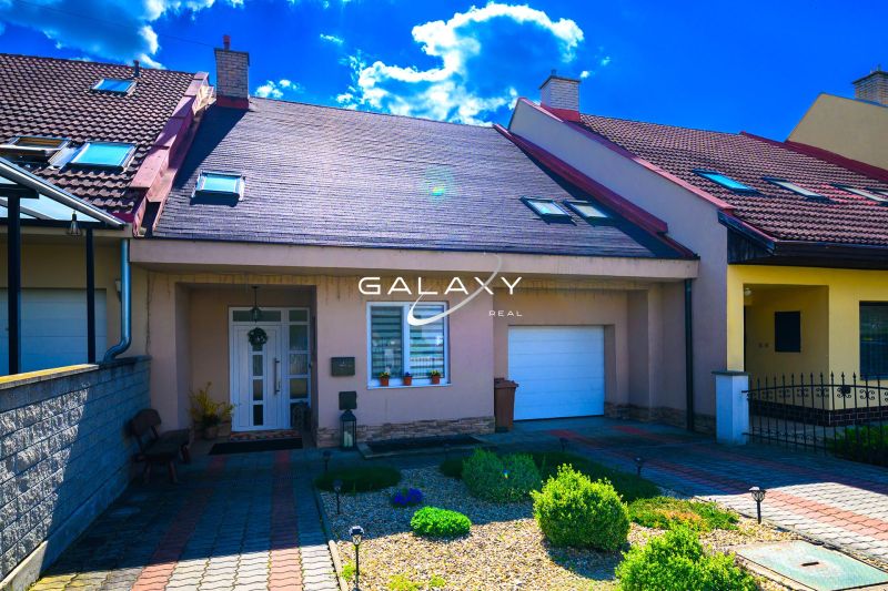 A family house in Rimavská Sobota with a garage and a sunny front garden.