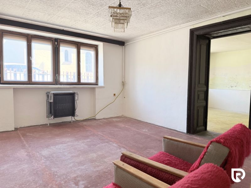 A small room with a sofa, radiator, and a large window, Properties - living.