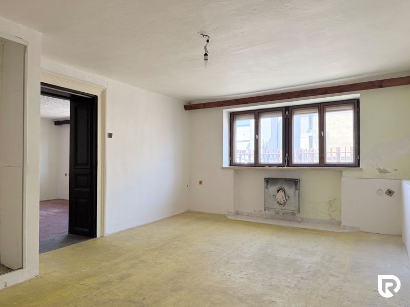 A furnished room in the renovation phase, real estate - residential, light penetrates through large windows.