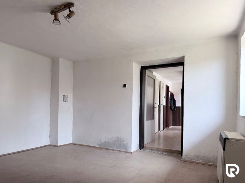Empty room with white walls and a floor with a wooden decor on Plots - housing.