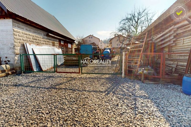 A courtyard with a gravel surface and a gate in the Recreational Grounds in Hybe.