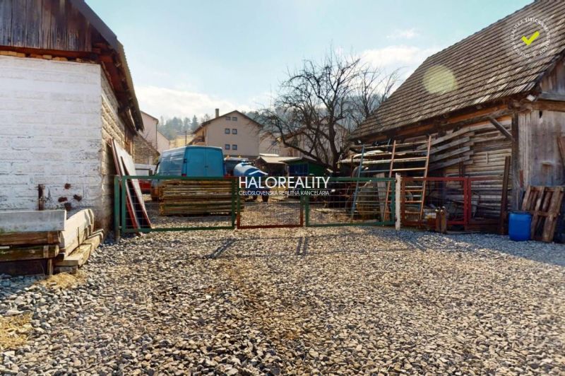 Stone courtyard with wooden buildings in the recreational grounds of Hybie.