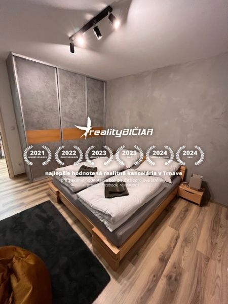Bedroom with a bed and wooden decor flooring in a 2-room apartment.