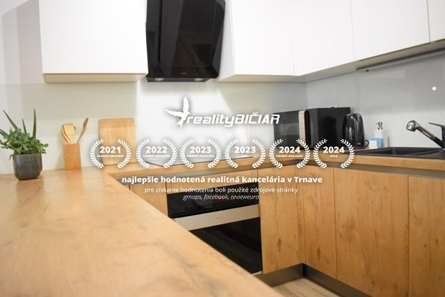 A kitchen in a 2-room apartment with a wood-patterned floor and dark appliances.