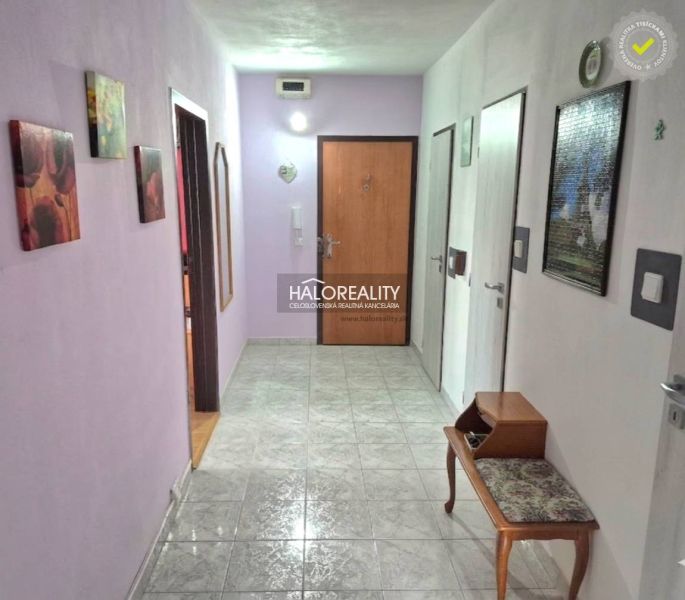 A hallway in a 3-room apartment with tiles, a bench, and wall decorations.