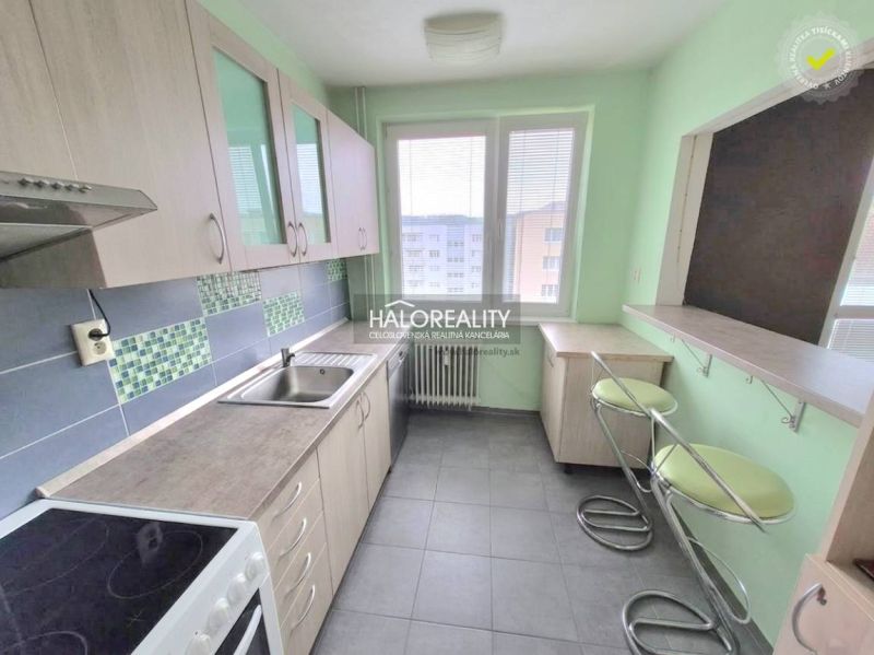 A kitchen with tiles and bar stools in a 3-room apartment.