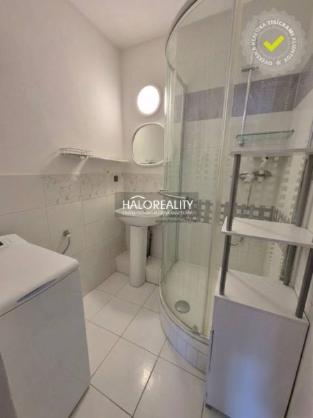 A bathroom with a shower, sink, and washing machine in a 3-room apartment.