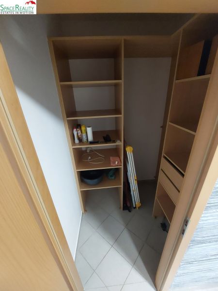 Wardrobe with shelves and various items in a 2-room apartment.
