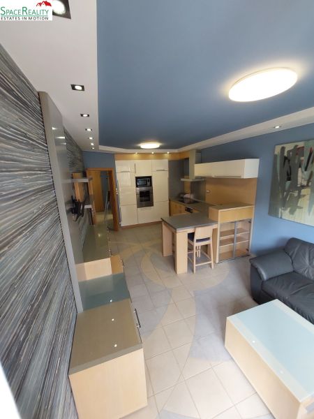 Living room with a kitchenette and a dining table in a 2-room apartment.