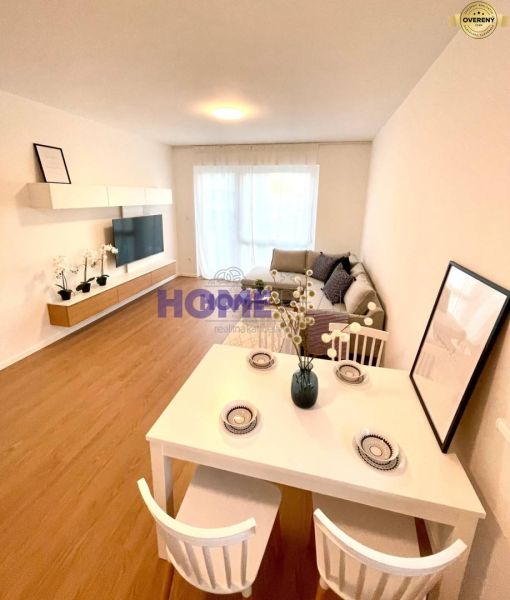 Living room with kitchen in a 3-room apartment with a wooden decor floor and white furniture.