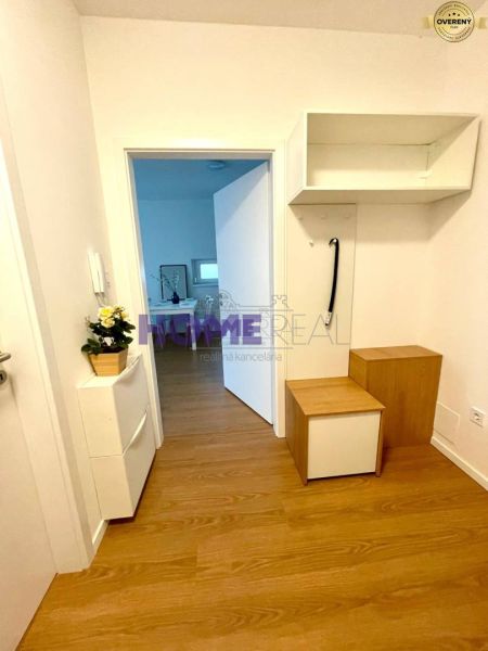 A hallway in a 3-room apartment with a wooden decor floor and white furniture.