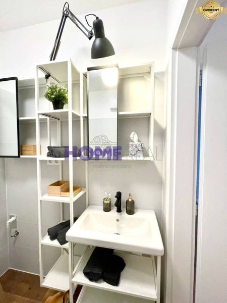 Compact bathroom with open shelves and a sink in a 3-room apartment.