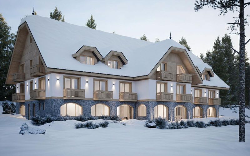 A snow-covered building in Hotels and Guesthouses in the High Tatras surrounded by trees.