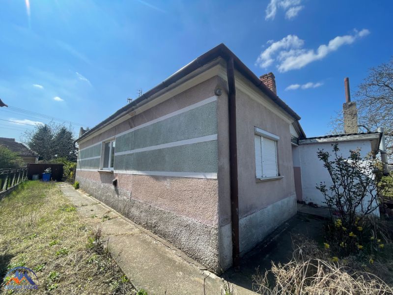 A family house in Bátorove Kosihy with a colorful facade and a concrete walkway.