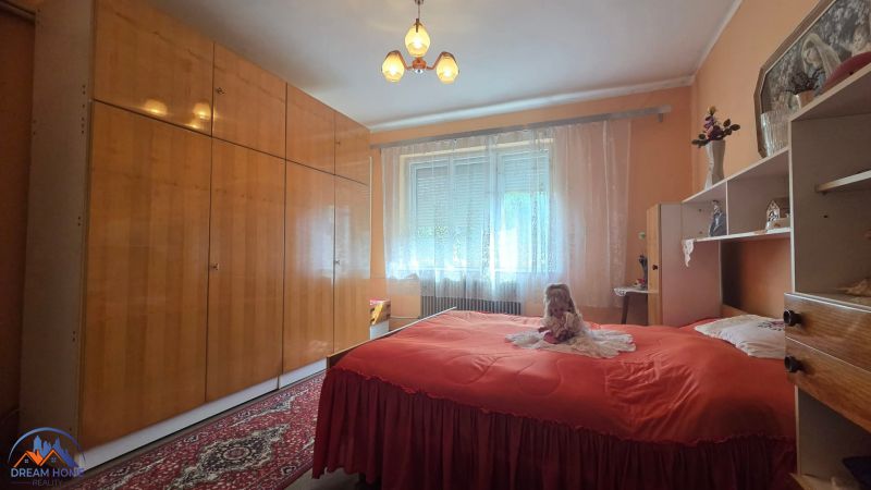 Bedroom with a large wardrobe and a red bed in a family house.