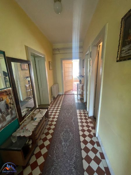 A hallway in a family house with tiles and a narrow carpet.