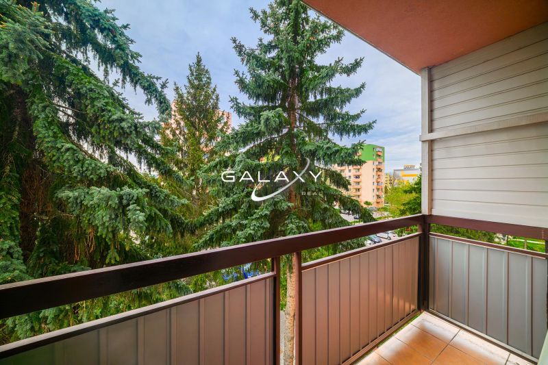 The balcony of a 2-room apartment on Sládkovičova Street in Fiľakovo with a view of greenery.