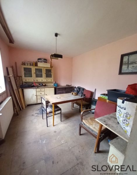 A room in a family house with wooden furniture and simple chairs.