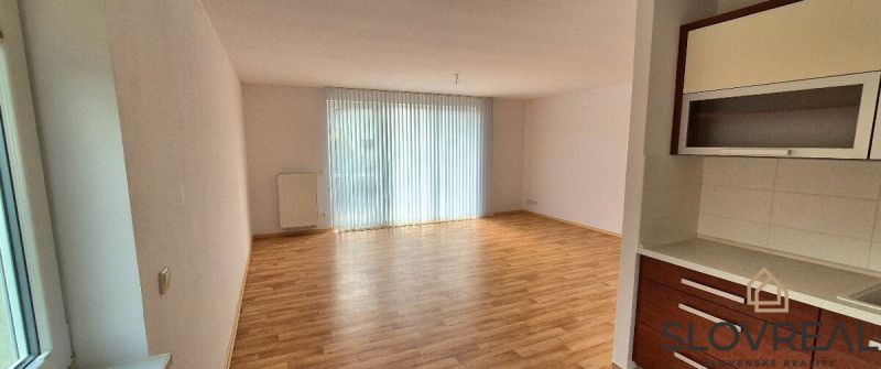 A room with a wooden decor floor and a kitchen nook in a family house.