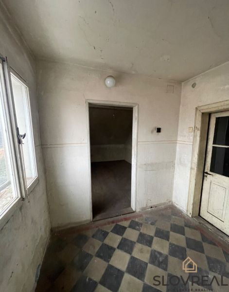 Entrance hallway of a family house with black and white patterned tiles.