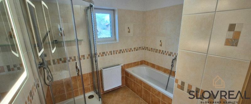 A bathroom with a corner shower and a bathtub in a family house.