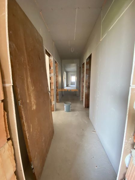 A hallway in a family house with construction material and a bucket on the floor.