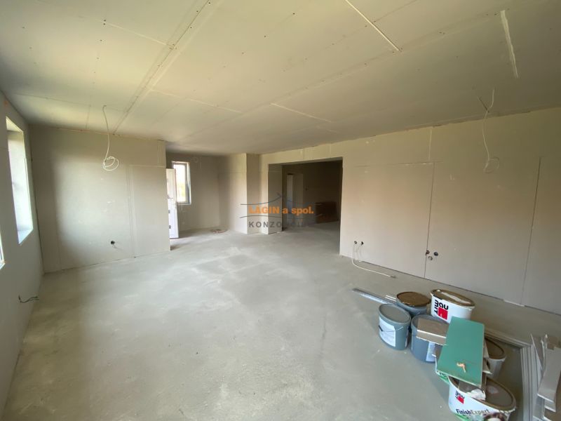 The interior of a family house during renovation, with white plaster and buckets of materials.