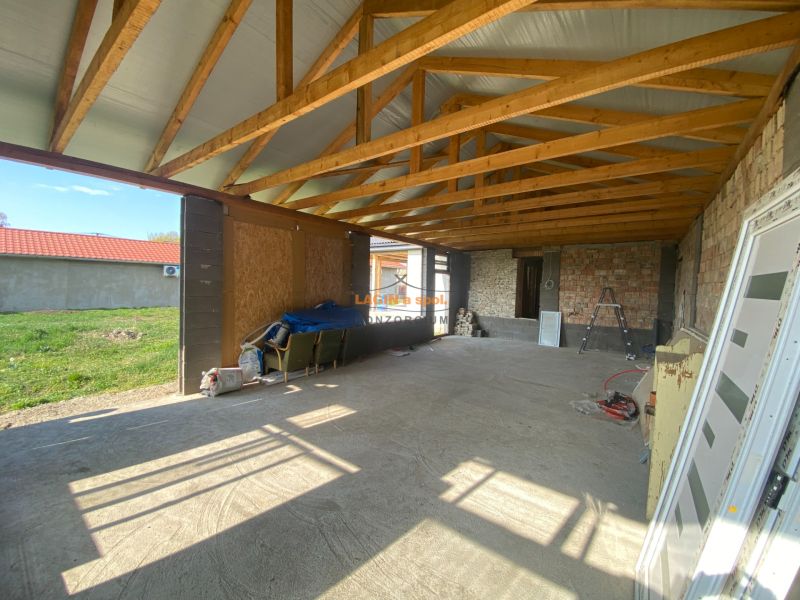 An unfinished family house in Encs with visible wooden trusses on a spacious structure.