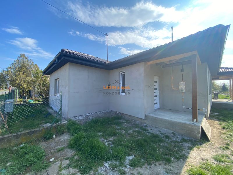 The family house in Encs has a simple facade and a sloped roof.