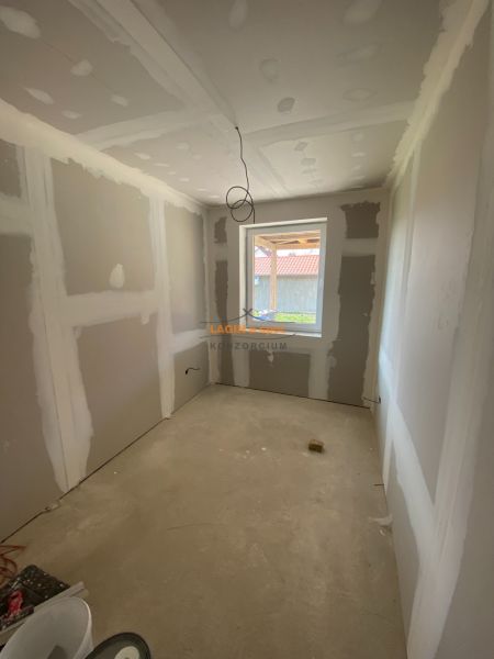 A room under construction in a family house with unfinished wall surfaces and a concrete floor.