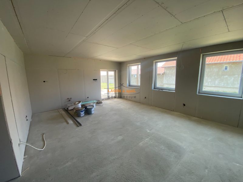 The interior of a family house with a concrete floor and unfinished walls.