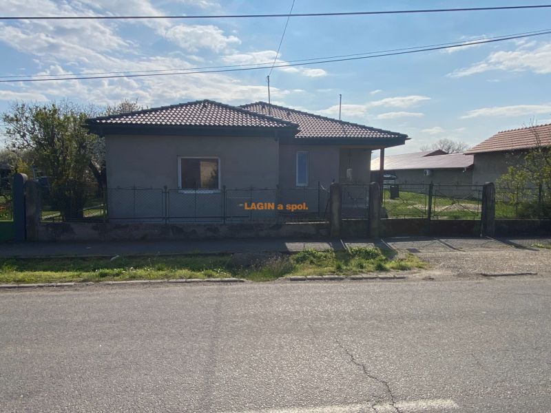 A family house in Encs with a garden and fencing, located by the road.