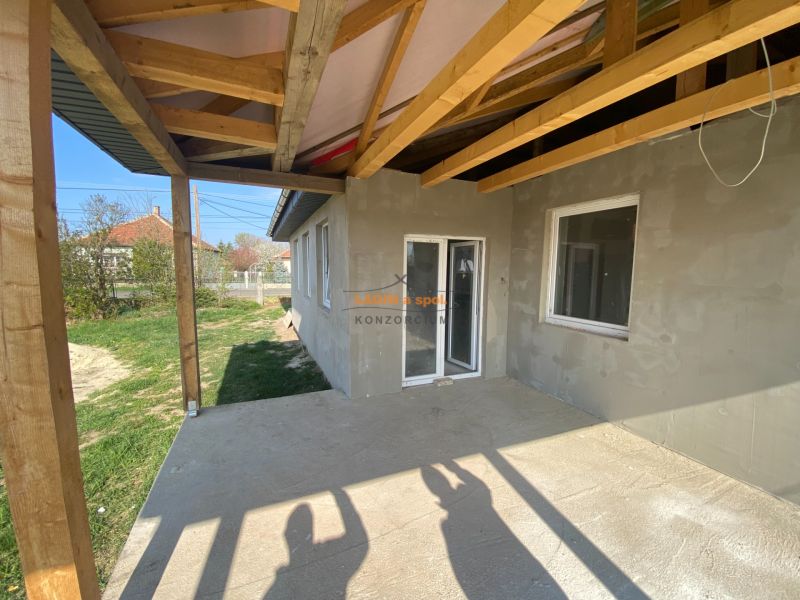 A view of the unfinished terrace of a family house in Encs with a wooden roof structure.