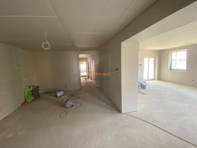 The interior of a family house with unfinished surface treatments and a concrete floor.