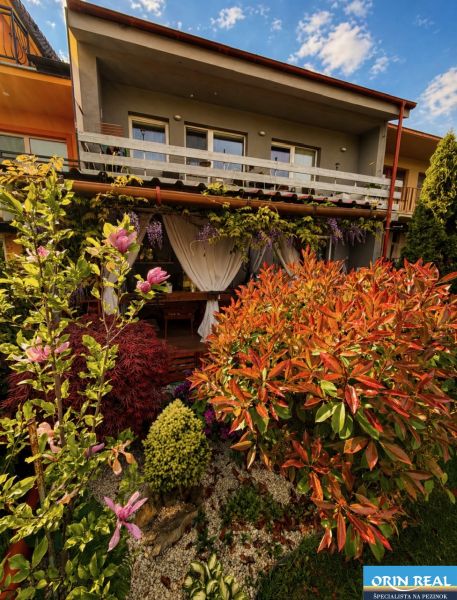 A family house on Muškátová Street in Pezinok with a landscaped garden full of flowers.