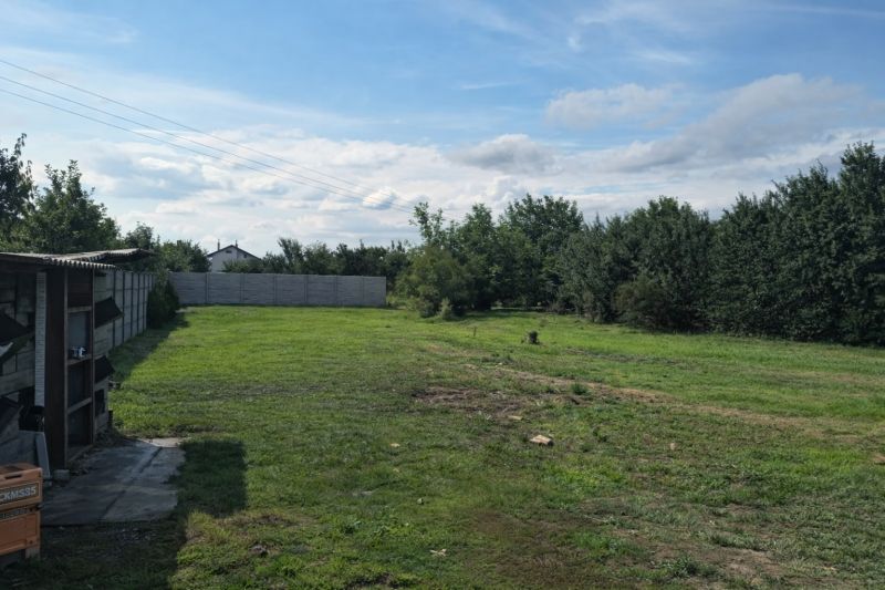 A grassy plot on Ábovská Street in Ždaňa surrounded by trees, suitable for residential land.
