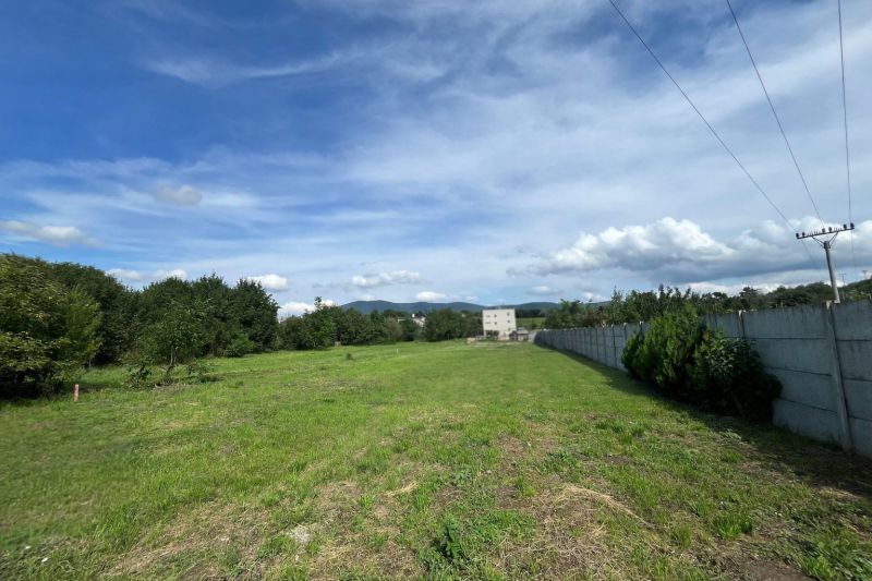 A plot on Ábovská Street in Ždaňa suitable for living, bordered by trees and a fence.