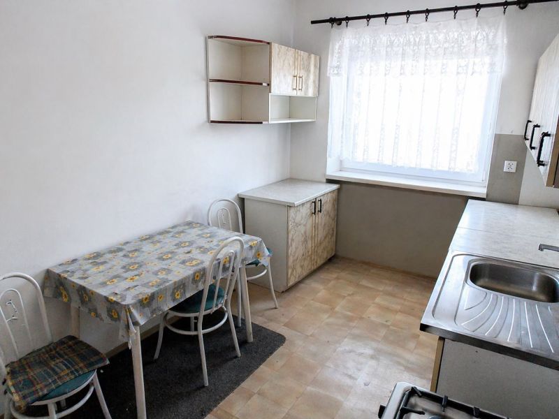 A kitchen in a 3-room apartment with a dining table, chairs, and a kitchen unit.