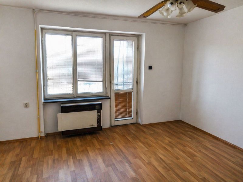 A room in a 3-room apartment with a wood-patterned floor and large windows.