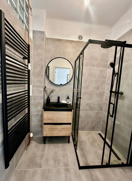 A bathroom in a 4-room apartment with a shower corner and a floor with a wooden decor.