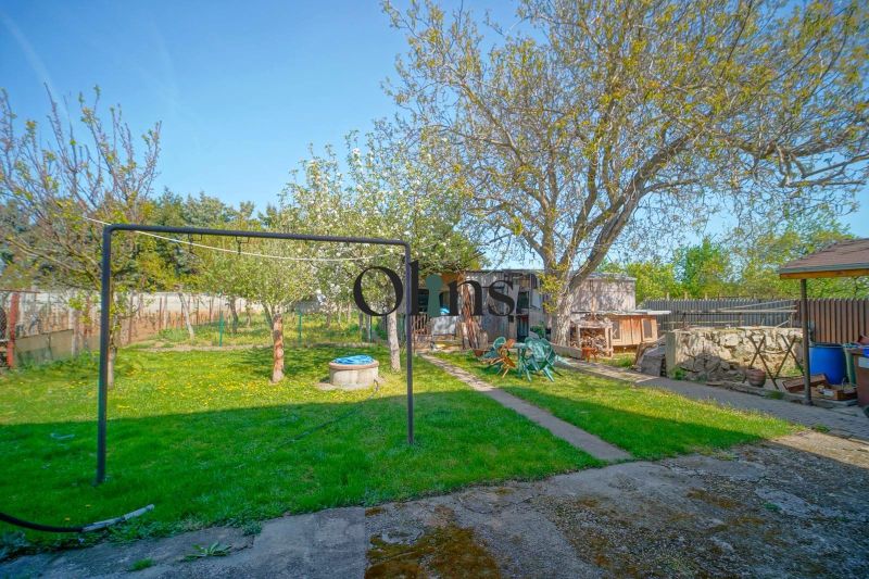 A garden in a family house in Veľký Lapáš with a lawn, trees, and garden furniture.