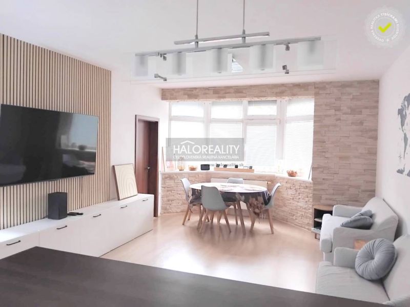 Living room in a two-room apartment with a television and a corner window, floor with wood decor.