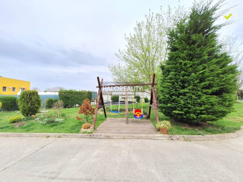 A garden with a swing surrounded by greenery in Podunajské Biskupice.