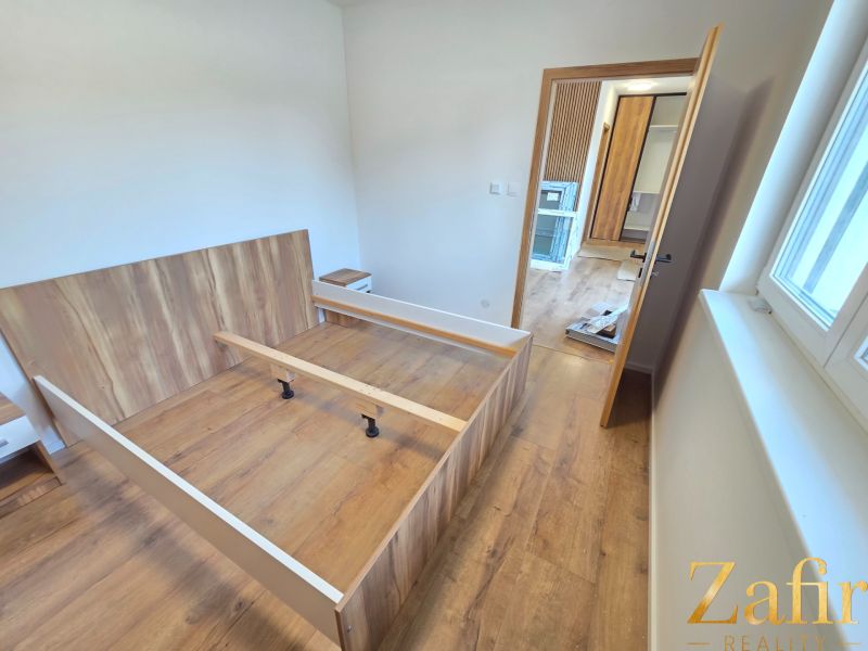 A bedroom with a bed and a wooden decor floor in a family house.