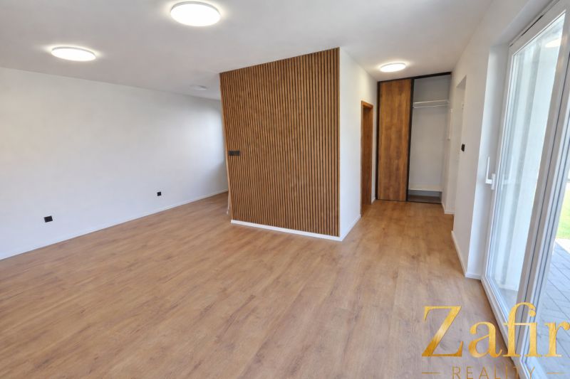 Interior of a family house with a wood-patterned floor and wooden details on the wall.